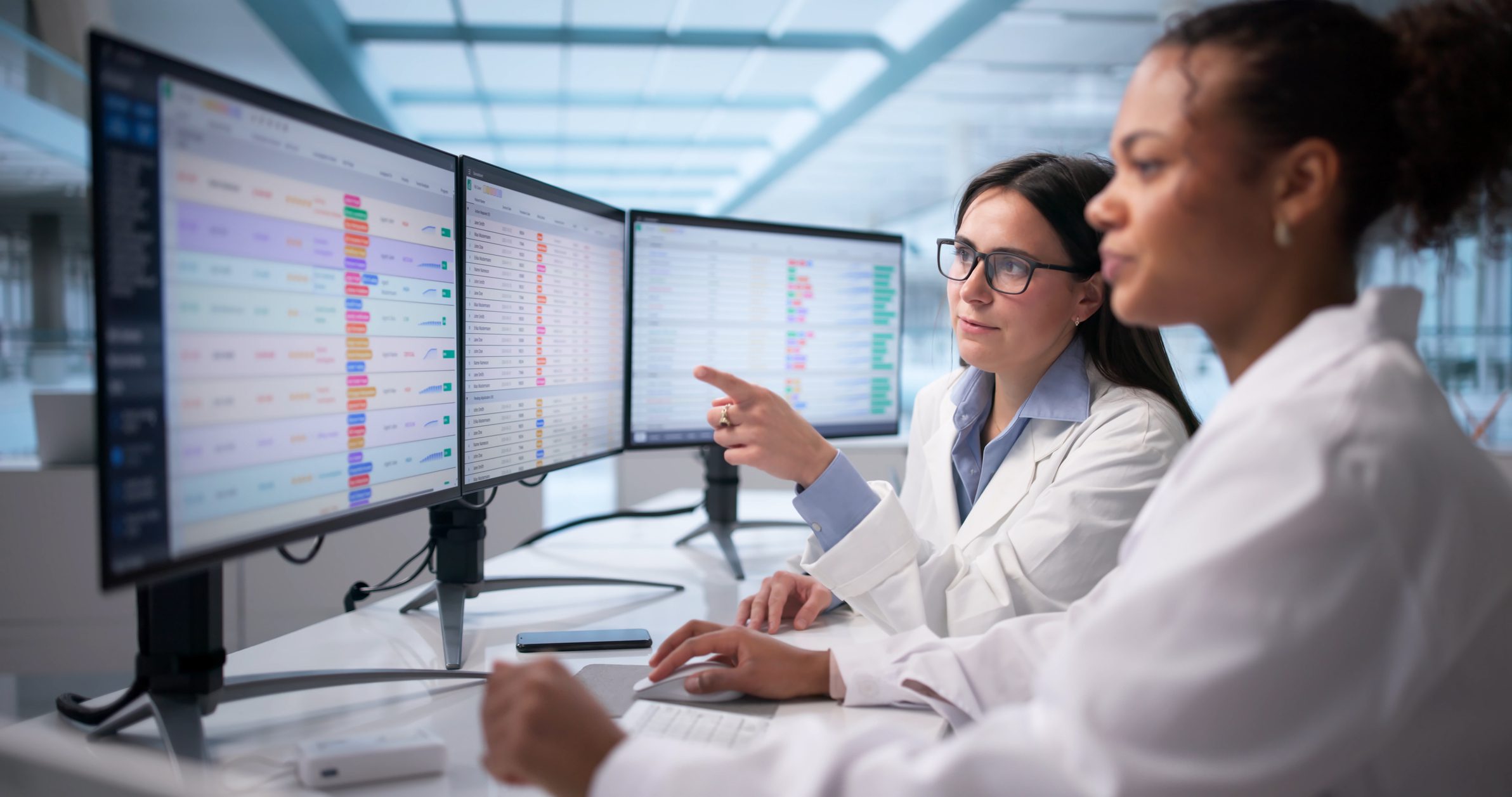 Professionals reviewing charts on monitors